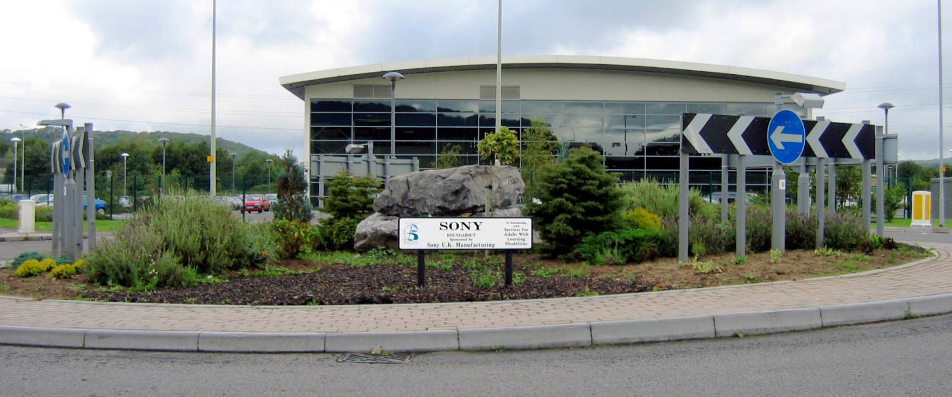 A roundabout next to a glass fronted building in Bridgend County Borough, which has a sponsorship board that clearly says ‘Sony’ and features our logo.