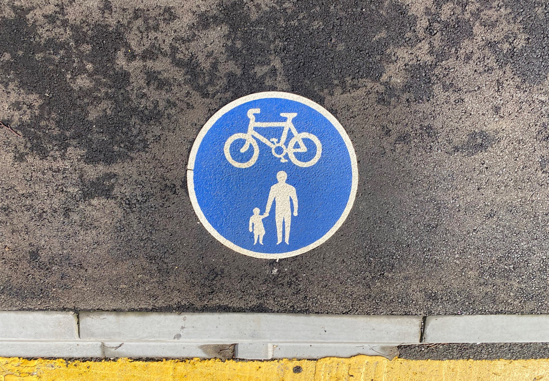 A road marking depicting a bicycle and a parent and child