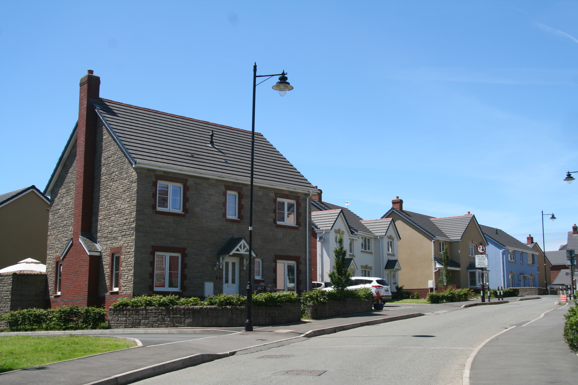 A street of suburban houses in sunshine.