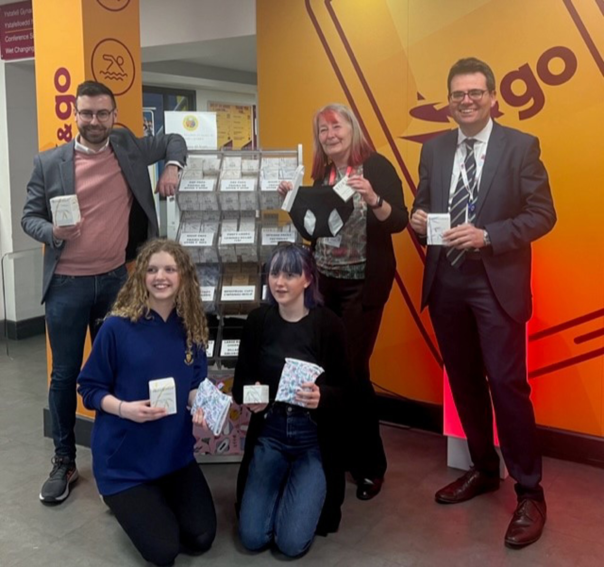 Group photo with selection stand of hygiene products in Bridgend Life Centre reception