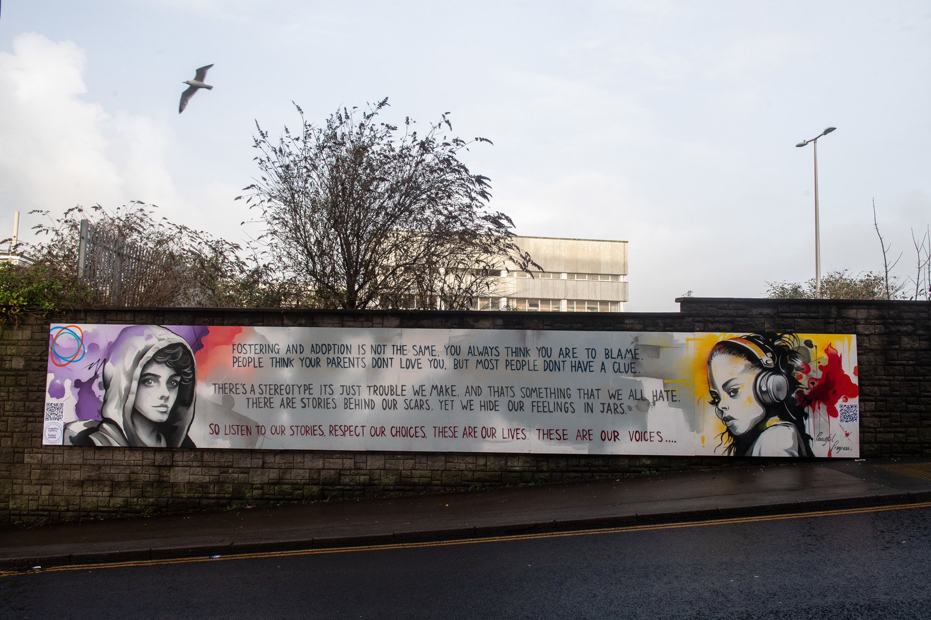 Poem as a mural on Brackla Street, Bridgend. The poem reads: Fostering and Adoption is not the same, you always think you are to blame. People think your parents don't love you, but most people don't have a clue. There's a stereotype it's just trouble we make, and that's something that we all hate. There are stories behind our scars, yet we hide our feelings in jars. So listen to out stories, respect our choices, these are our lives, these are our voices.